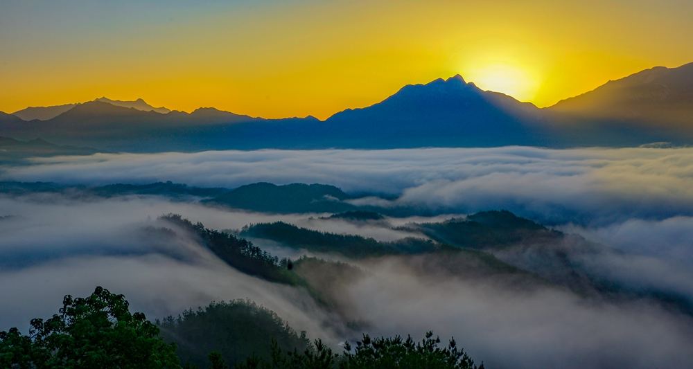 大别山九资河的清晨，云海之上旭日初升，群山静静铺开